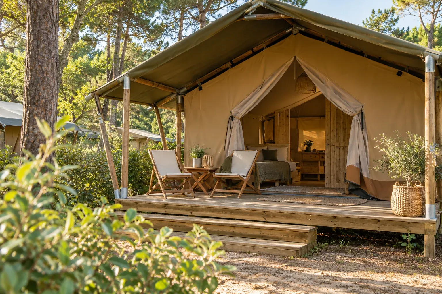 Ingerichte safaritent met een houten veranda en buitenstoelen.